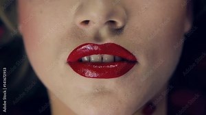 Video footage shot close-up of a girl's lips with red lipstick. The girl opens her lips. Slow motion. Professional lighting on the face of the girl in the studio. Shows teeth. In frame lip,nose,chin. Stock Video