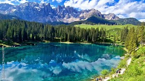 Idyllic nature scenery- trasparent mountain lake Carezza surrounded by Dolomites rocks- one of the most beautiful lakes of Alps. South Tyrol region. Italy