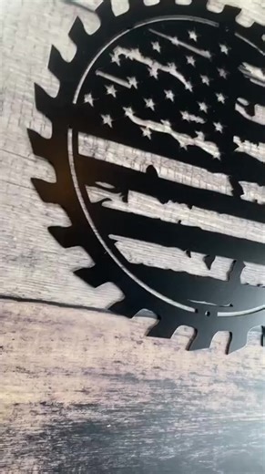 Show off your American pride with this bold and artistic American Flag Sawblade Wall Decor. Expertly crafted from high-quality metal, this unique piece of wall art features a distressed, tattered rendition of the American flag set on a classic circular sawblade design. Its rugged, industrial look makes it perfect for patriotic home decor, shops, garages, and man caves alike. Size & Material Highlights: Material: Durable metal (steel or aluminum depending on variant)Finish: Available in handgroun