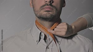 Tailor measuring different parts on a mans body for a suit production. Measures for making men's suits. Textile confection.