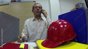 Successful Businessman Talking on Mobile Phone in the Office / Busy businessman surrounded by paperwork using mobile phone in office