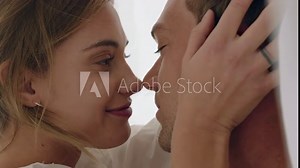 happy young couple lying in bed kissing under sheets sharing romantic relationship enjoying intimacy together at home 4k Stock Video