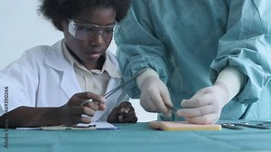 Education concept of 4k Resolution. Medical school students practicing suturing wounds in classroom. internship doctor. training simulation.