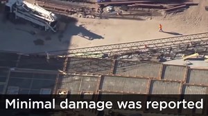 Dramatic narrow miss: Workers sent running for their lives as crane topples over