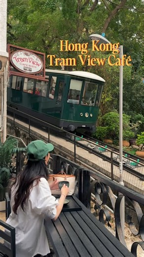 V i v i a n ✿ travel+lifestyle VANCOUVER on Instagram: "Save this Peak Tram View Café in HK 🇭🇰✨⁣ Hidden right next to the Peak Tram station, this quiet gem gives you an up-close view of the historic trams plus local student + artist artwork that adds a creative flair 🎨⁣ ⁣ Coffee’s decent, but the peaceful vibe and stunning view? 10/10. You’d never guess it’s steps from the crowds!⁣ ⁣ 📍Tram View Cafe 2 Tramway Path, Mid-Levels, Hong Kong #discoverhongkong #centralhongkong #香港打卡 #hongkongtrip"