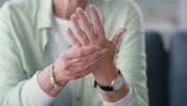 Closeup wrinkled hands of a mature woman suffering with arthritis....