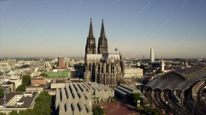 The cathedral in Cologne callend Dom zu Köln. The drone is rising into the sky showing the architecture in the city center of the capital or NRW, Germany.