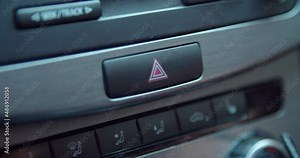 Pressing the car's emergency stop button. Pressing the car emergency hazard lights button close up