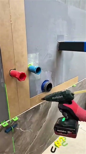 installing protective cardboard over plumbing pipes and bathroom tile for wall construction work