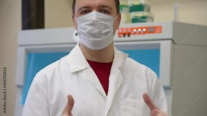Confident doctor in mask talking look camera biomedical laboratory.Scientist standing in vintage style laboratory and giving speech. Happy scientist in room with laboratory box in UV light