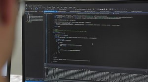 clip-1031416061-black-computer-screen-engineer-developing-software-app