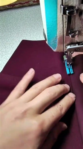 Sewing maroon fabric using a professional machine to create neat and firm seams