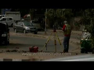Surveyor at work with a leveling instrument on an Indian construction site