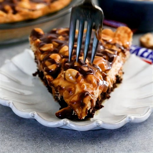 6.9K views · 67 reactions | Snickers Pie takes all the incredible elements of a Snickers bar and turns it into this masterpiece! It starts with a moist brownie, then has a layer of peanut butter nougat and is topped with peanuts and caramel. Can’t get any better than that! See all the details here: https://www.crazyforcrust.com/snickers-peanut-butter-pie/ | CrazyforCrust | Facebook