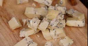 hard cheese with blue mold on the cutting board, blue mold with cream cheese during cutting