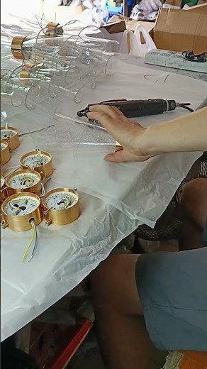 China Lighting Factory:The worker who is manually assembling the lighting fixtures