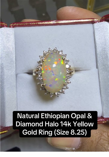 This stunning solid 14K yellow gold ring showcases an exceptional 8.80 carat natural Ethiopian opal bursting with vivid flashes of red, orange, green, and blue from every angle. Expertly cut to maximize its play-of-color, the opal retains a small natural potch (host rock inclusion) — intentionally left during cutting as visible proof that this gemstone is 100% natural and earth-mined, not synthetic or treated. Surrounding the opal is a dazzling halo of 22 round brilliant-cut natural diamonds tot