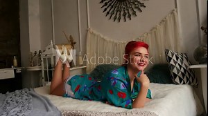 Beautiful red-haired girl on the bed. A woman in a pinup style at a photo shoot.