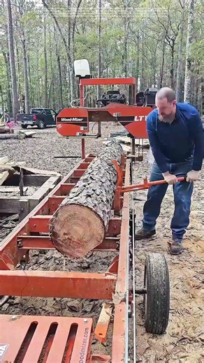 Woodcutting Precision: Man Operates Machinery to Cut Logs