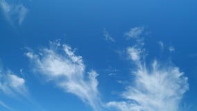 Scenic cirrus lenticular clouds. Stunning cirrus cloud formations in a deep blue summer sky. Time lapse.