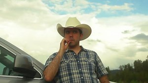 Chewing on a piece of straw, cowboy country person