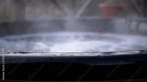 Empty Boiling Vat with Hot Water from Thermal Springs Outdoors. Abstract. Water evaporation, hot sauna. Surface. Stream of water, fountain, foam. Bubbling jacuzzi, open pool. Bubbles, steam. Nobody.