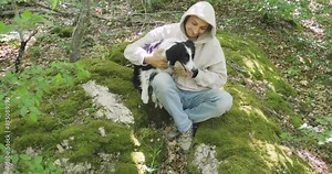 Canistherapy lesson. Social and medical rehabilitation. A man with a border collie dog sits in the forest. Slow motion