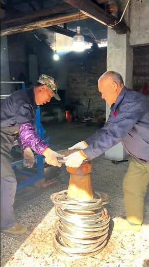 伝統的な圧搾製法で油かすを分離する作業