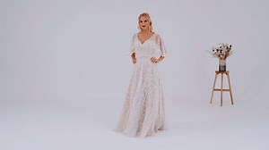 22 reactions · 4 comments | Sage is a stunning modern bridal gown with a bohemian twist. This delicately beaded lace style features a plunging front and back neckline with a crossover twist to the front with a strapless bodice underneath. We love the romantic waterfall cape that leads to a soft full A-lineskirt with a front split. A stunning lace train and a beautiful handed beaded pearl and opal belt complete the effortlessly elegant look. | True Bride | Facebook