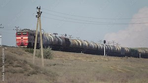Railway freight train with tank cars moving through the semi-desert