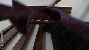 A man hangs a T-shirt and shirt on the hook of a hanger. Ironed clothes are on trempels.
