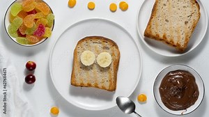 Stop motion animation of making a cute sweet sandwich for kids with toast bread, chocolate spread, marmalade and fresh fruit
