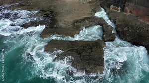 Aerial view of Victoria Beach with the famous pirate's Tower, an area of Orange County California for the wealthy and affluent, shows the crashing waves and they roll over jagged shoreline reefs.