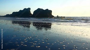 Ruby beach on the Olympic National Park coast in Washington with reflection of waves crashing onto rocky outcroppings and coming up the beach.