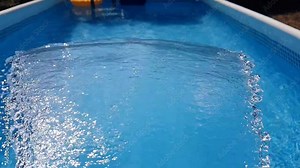 A small waterfall injects water into the swimming pool, which circulates through an activated carbon filter and purifies the water Stock Video