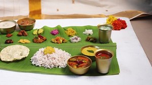 Traditional Onam sadhya with rice Sambar dal curry ghee payasam served on banana leaf. Special food for Vishu Pongal Diwali festival vegetarian food Kerala Tamil Nadu South India.