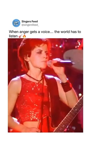 SingersFeed | Singing & Pop Culture on Instagram: "Drenched in raw emotion and unapologetic roar — The Cranberries’ ‘Zombie’ live is a reminder that music can shout when words fail. 🔥 “Zombie” by The Cranberries (originally released in 1994) is a haunting protest anthem born from sorrow and rage. It was written in response to violent conflict, and its repeated “zombie” refrain evokes the numbness and trauma of loss. The 1999 live video captures the band at the height of their power — turning an