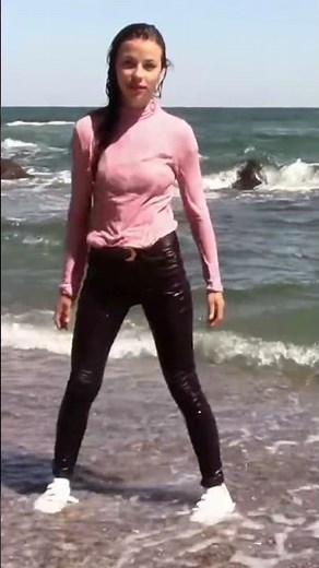 WETLOOK VIDEO! A CHARMING GIRL POSE AWESOMELY IN WET CLOTHES ON THE BEACH BY THE SEA