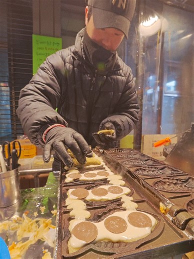 긴 줄 끝에 만난 신원시장 두바이 초코 붕어빵 신원시장 입구, 유독 긴 줄이 눈에 들어옵니다 입김이 나오는 추운 날씨지만 사람들의 발길은 계속 이어집니다 긴 기다림 끝에 받아든, 갓 구운 따끈한 붕어빵 한 마리 반으로 가르니 꾸덕한 카다이프와 피스타치오가 빈틈없이 들어차 있습니다 [신원시장 고은이네] 📍 위치 서울 관악구 관천로 17 (2호선 신림역 3번 출구 도보 5분) ⏰ 영업시간 매일 낮 12시 - 저녁 8시 30분 매월 둘째, 넷째 화요일 휴무 ※ 재료 소진 시 조기 마감 🎞️ 영상 속 메뉴 두바이 초코 붕어빵 ₩5,000 (1인 2~3마리 구매 제한) ※ 촬영일 기준, 가격 변동 가능 - Dubai Choco Bungeoppang at Shinwon Market After a Long Wait At the entrance of Shinwon Market, a notably long line catches my eye Despite the cold weather with 