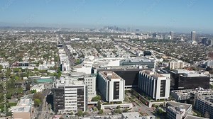 Aerial view of Beverly Hills shops, commercial buildings, homes, LA skyline