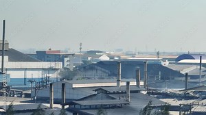 Grim industrial estates release choking smoke into the sky, a haunting aerial view reveals a desolate landscape. Respiratory Illness and Environmental Hazard concept.