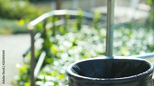 Close up portrait of a woman hand throwing trash into bin in a park in slow motion