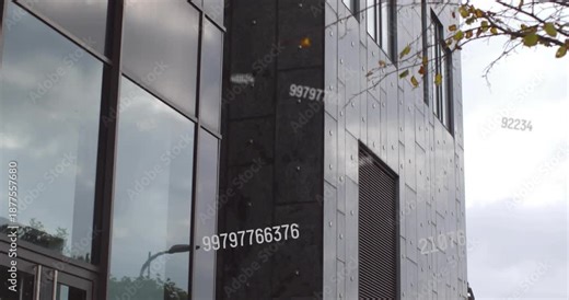 Numbers appearing then drifting while camera tilting up revealing glass and cladding showing data