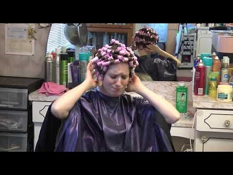 Woman pouting and mad with perm rods in her hair at the salon