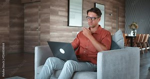 Man glasses sits chair, typing laptop, technology daily life. commonplace integration laptops, technology various tasks. modern digital devices work personal projects, presence utility technology.