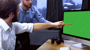 Two developers working on a project at trendy start up office, discussing project on a computer screen. Chroma key. 4K UHD 60 FPS slow motion