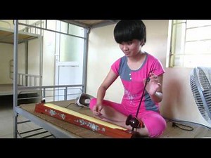Vietnamese student plays the đàn bầu (traditional instrument)