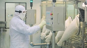 Worker at pharmaceutical factory operating control panel of the pharmaceutical machine. Pharmaceutical Factory Workers. Pharmaceutical Manufacturing