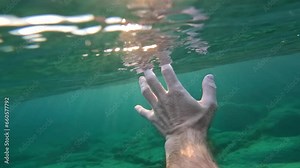 Man's hand drowning in the sea