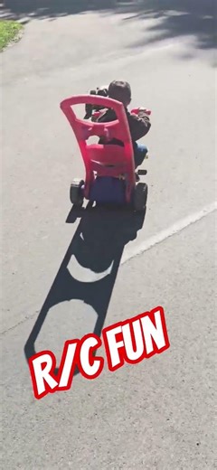 r/c car pulling kid on a trike.